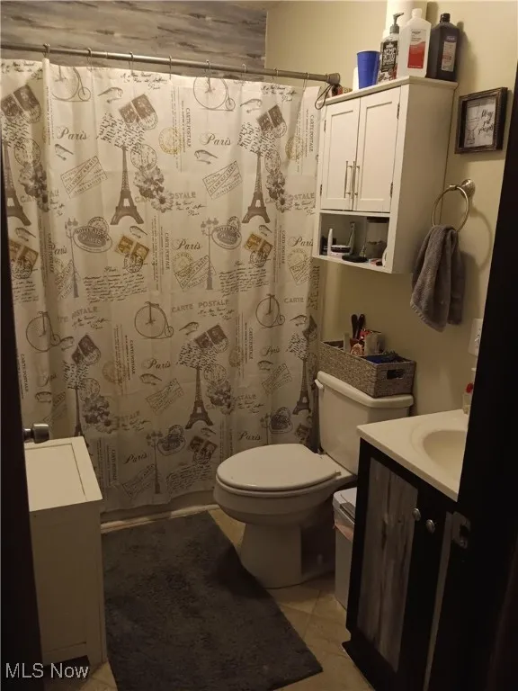 Full bath with vanity and light tile patterned flooring