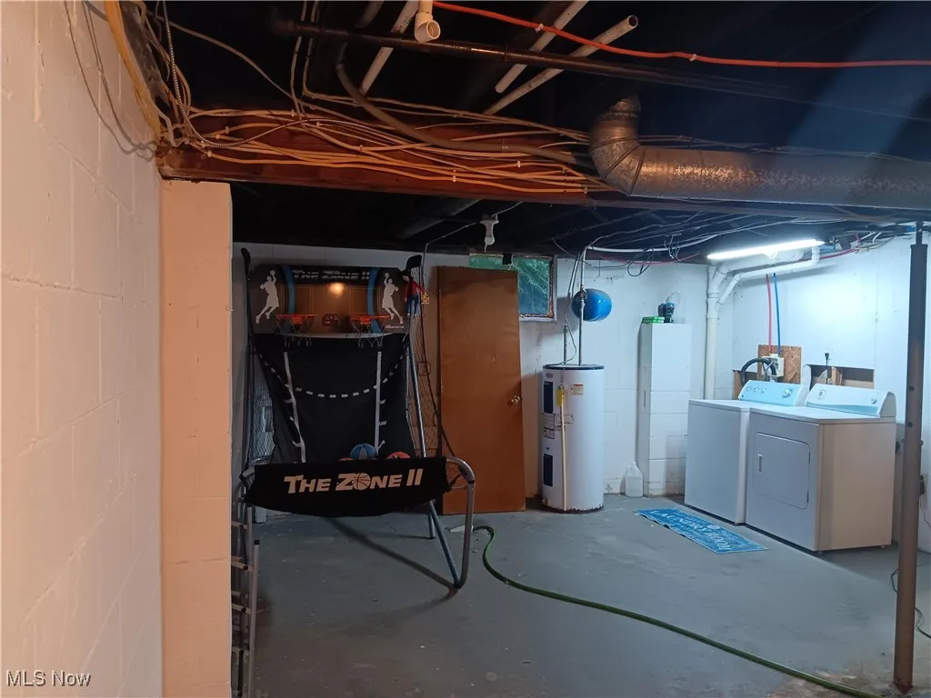 Unfinished basement with electric water heater and washer and clothes dryer