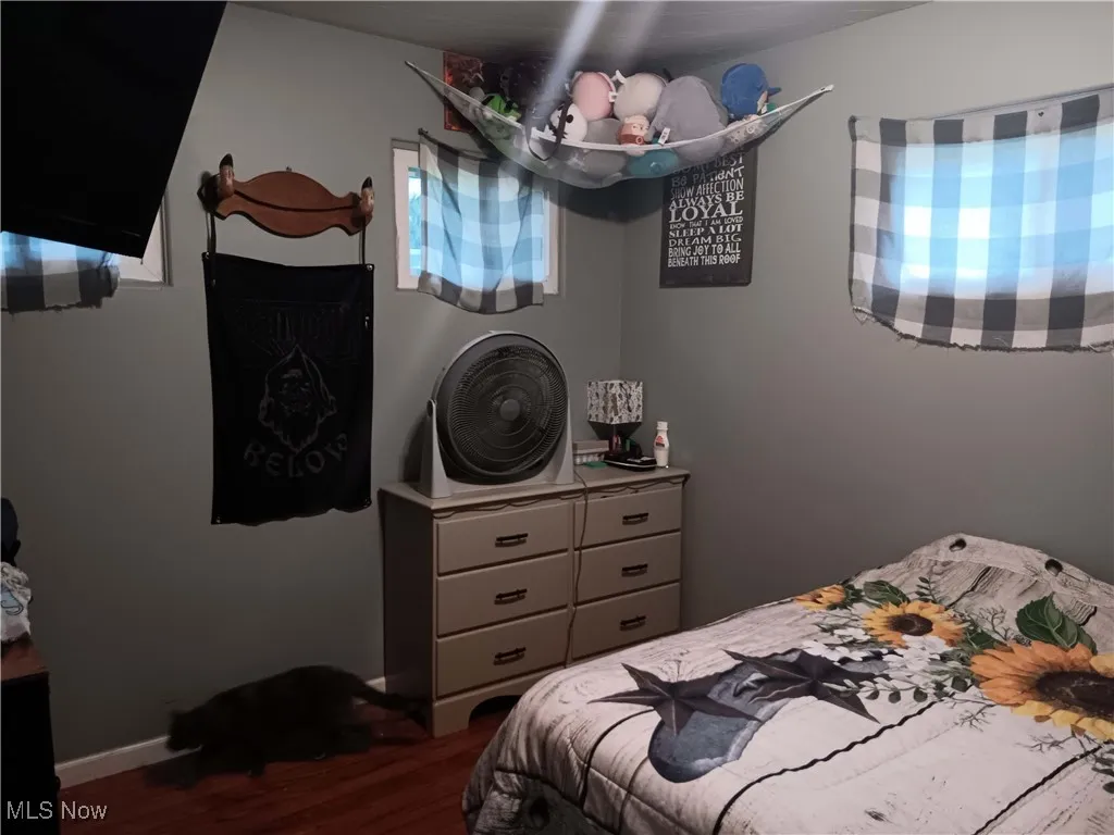 Bedroom featuring dark wood-type flooring and baseboards