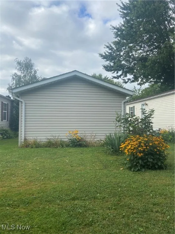 View of property exterior featuring a lawn