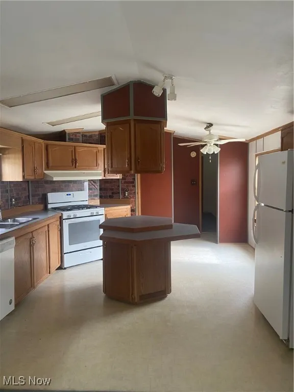 Kitchen with light floors, range, fridge, and ceiling fan