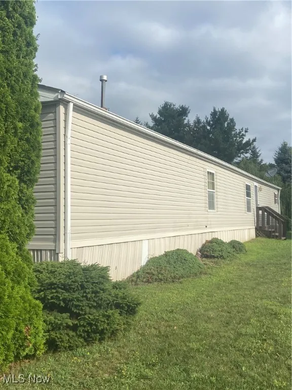 View of side of property with a yard