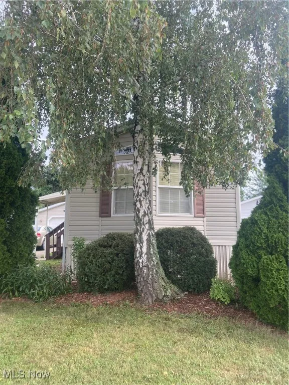 View of side of home with a yard