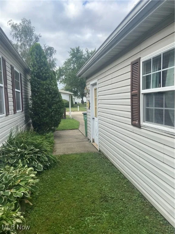 View of side of property with a lawn