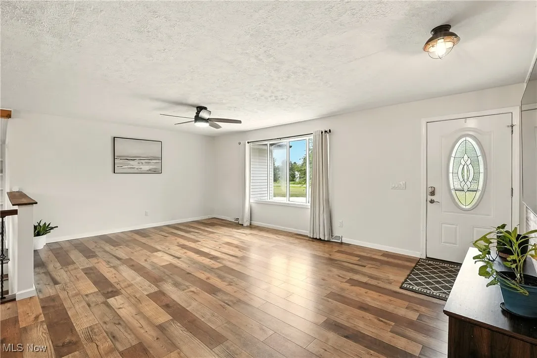Foyer with a textured ceiling, hardwood / wood-style flooring, and ceiling fan