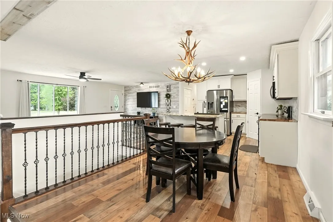 Dining area with healthy amount of natural light, light wood-style floors, a chandelier, and recessed lighting