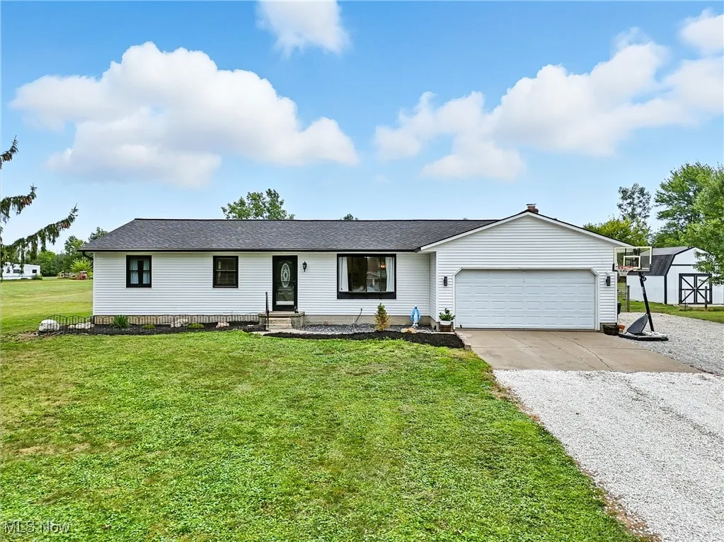 Ranch-style house featuring driveway, a front lawn, a garage, and a shingled roof