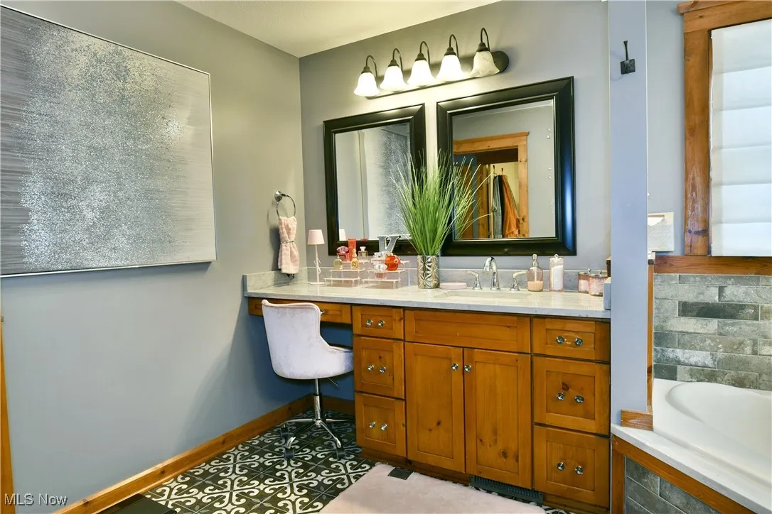 Full bathroom with vanity, a garden tub, tasteful backsplash, and light tile patterned flooring