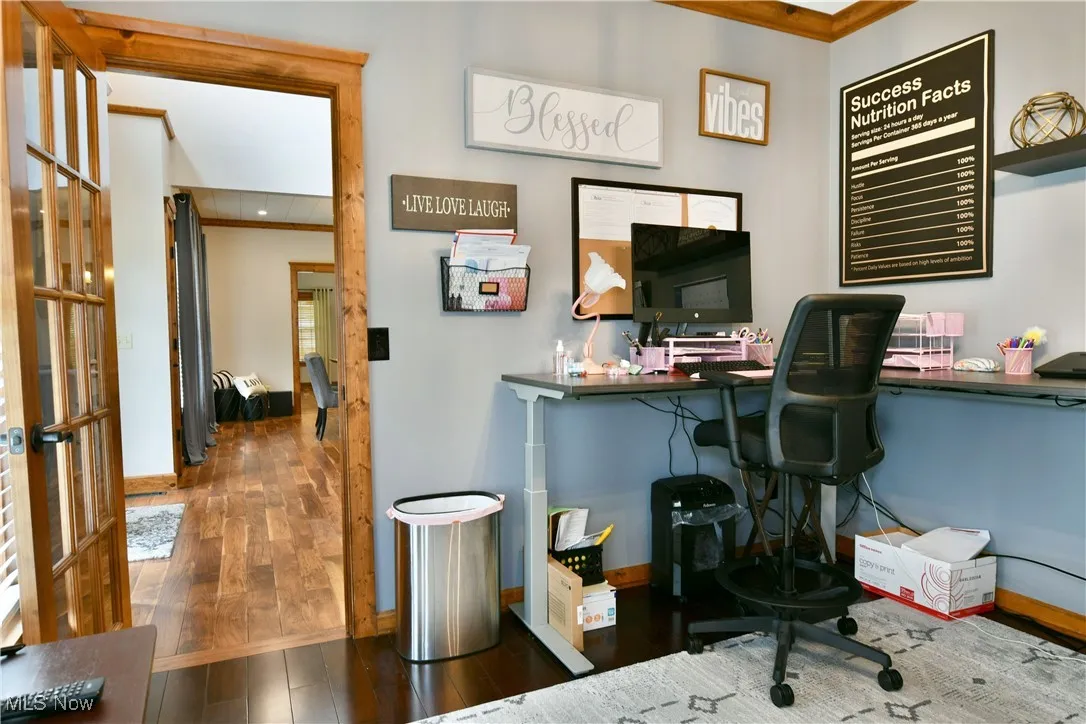 Office featuring dark wood-style flooring, ornamental molding, and french doors