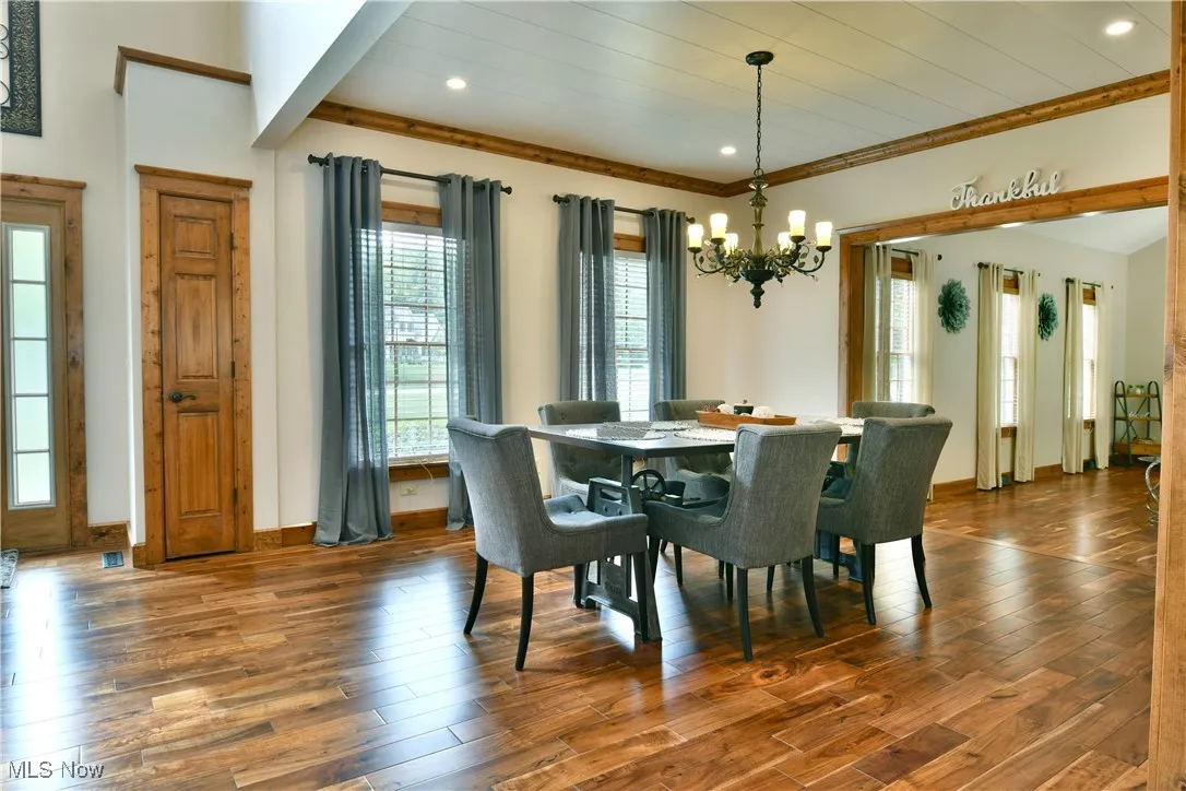 Dining area featuring healthy amount of natural light, wood-type flooring, a chandelier, and recessed lighting