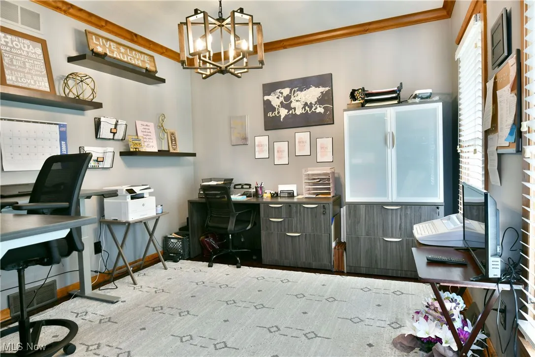 Office area featuring a chandelier and baseboards
