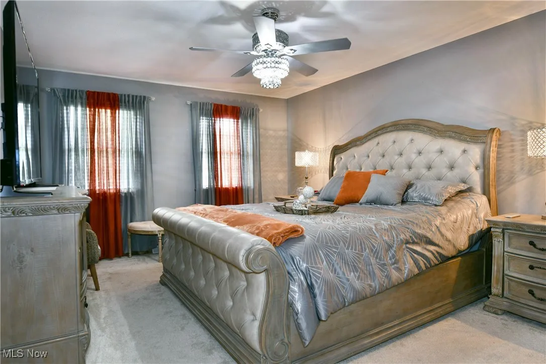 Carpeted bedroom featuring ceiling fan