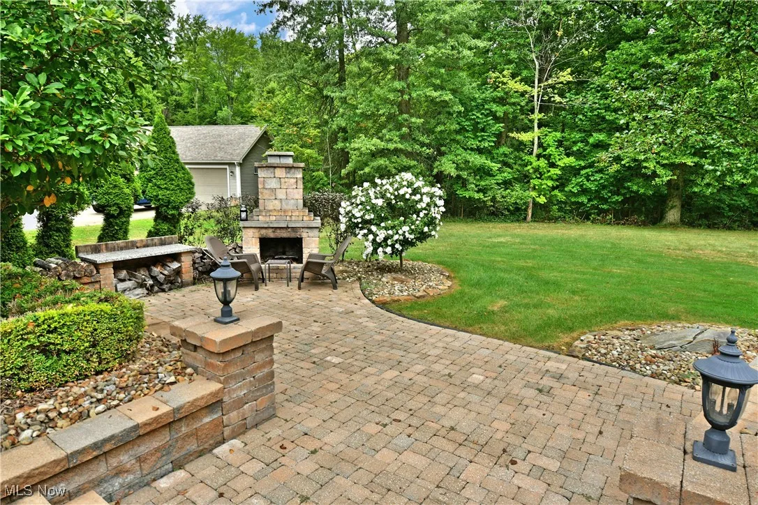 View of patio with an outdoor stone fireplace