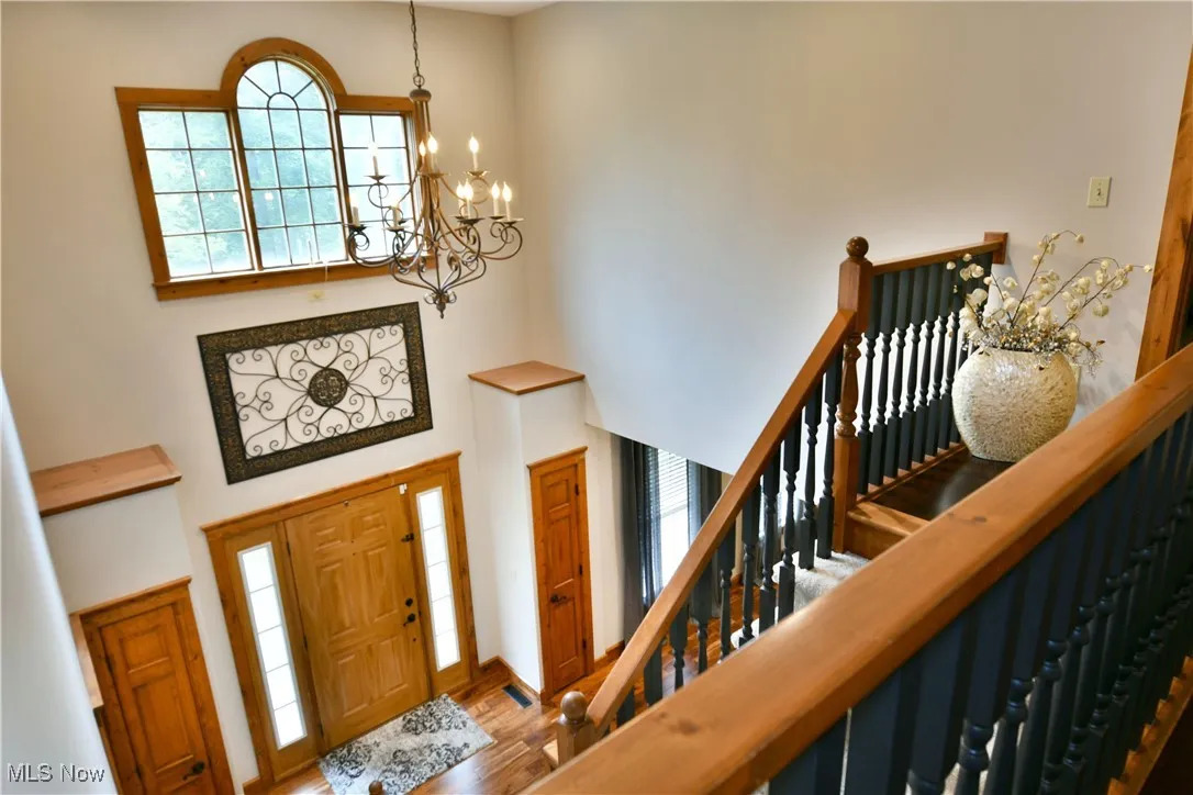 Entrance foyer with a high ceiling, a chandelier, and wood finished floors