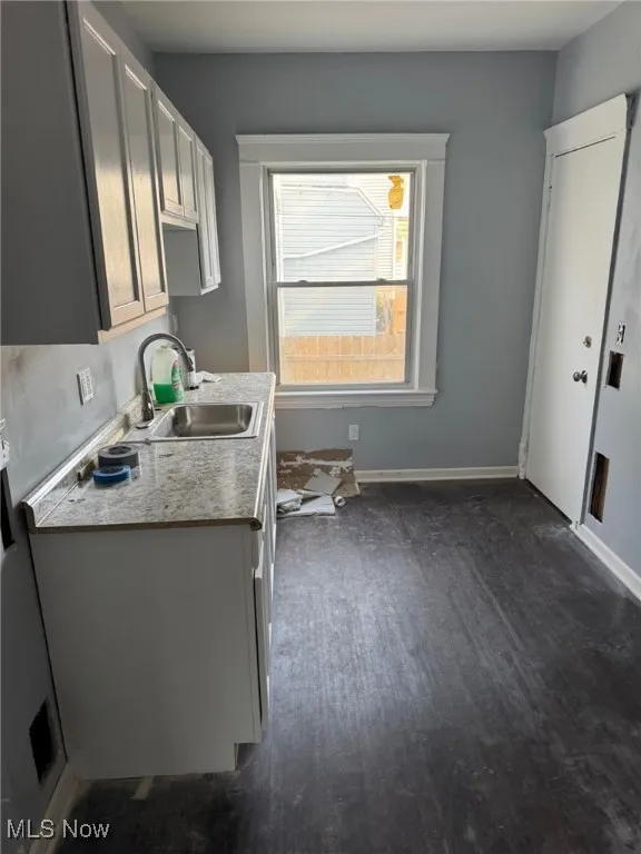 Washroom with dark wood-type flooring and baseboards
