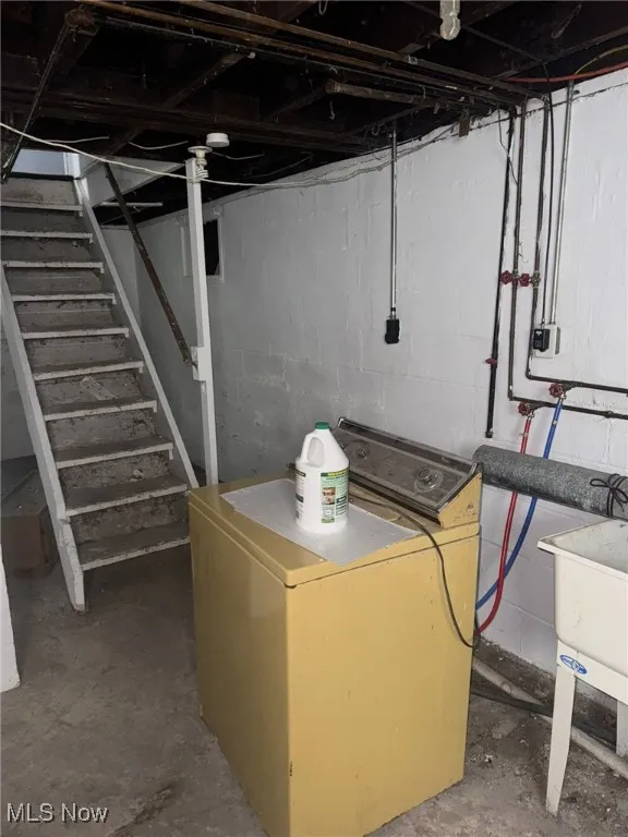Unfinished below grade area featuring washer / dryer and stairs