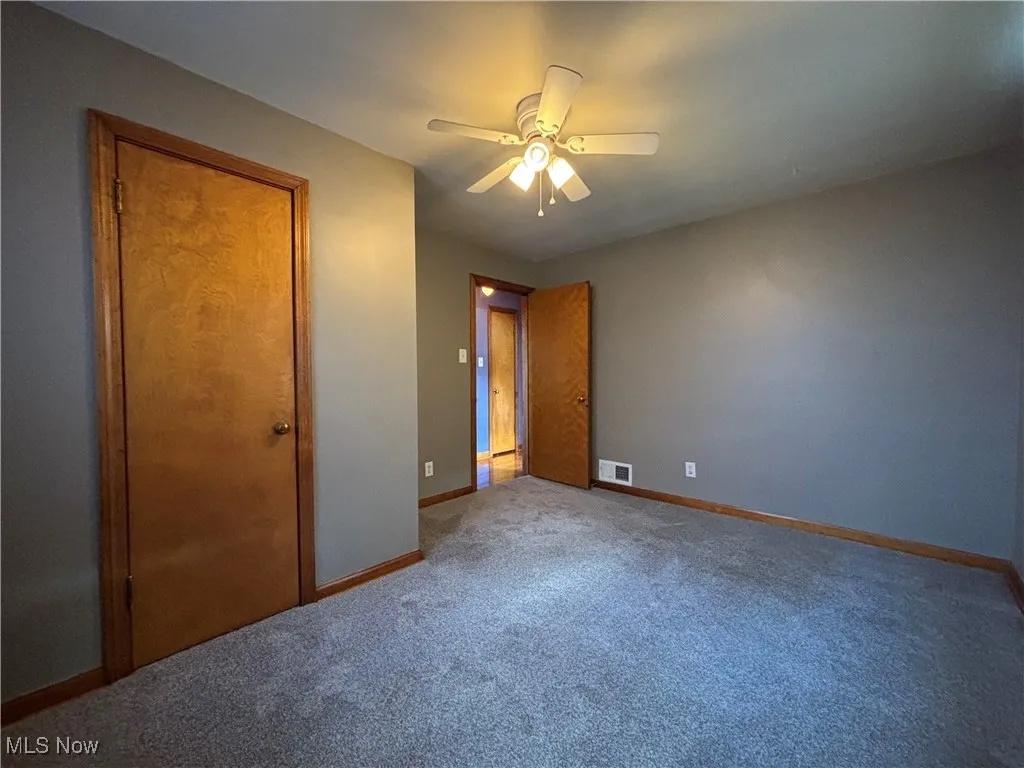 Unfurnished bedroom featuring carpet flooring, a ceiling fan, and a closet