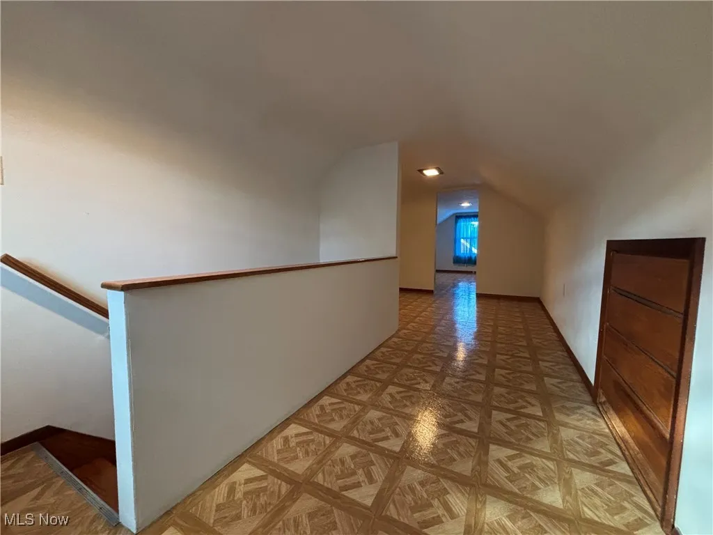 Additional living space with baseboards and lofted ceiling