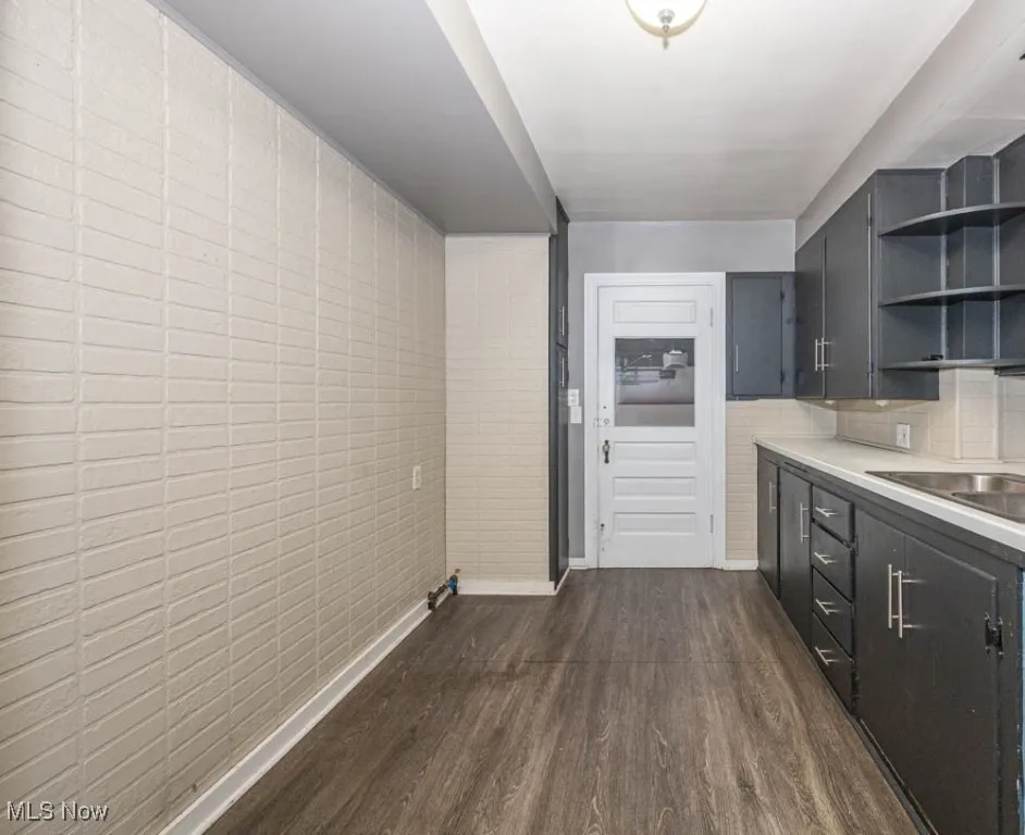 Kitchen with plenty of cabinetry, light countertops, wood-like finished flooring