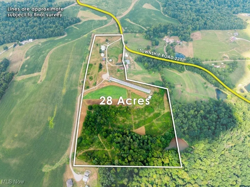Aerial view of property and surrounding area featuring property boundaries highlighted and a tree filled landscape
