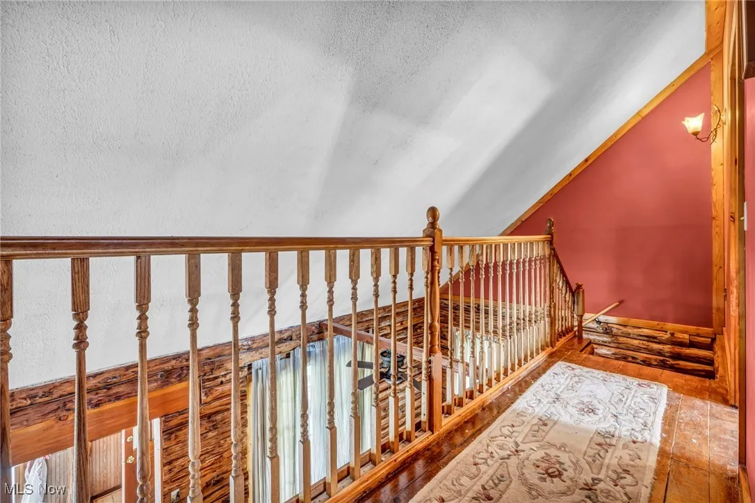 Stairs with vaulted ceiling and a textured ceiling