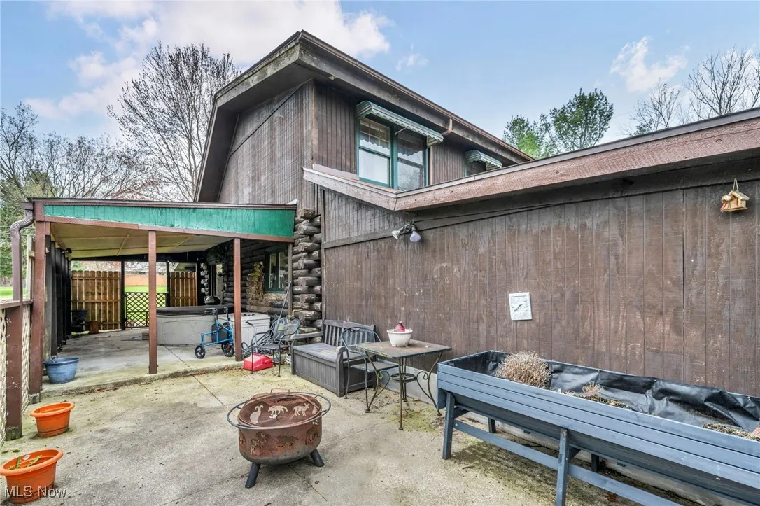 Rear view of property featuring a patio area, an outdoor fire pit, and fence
