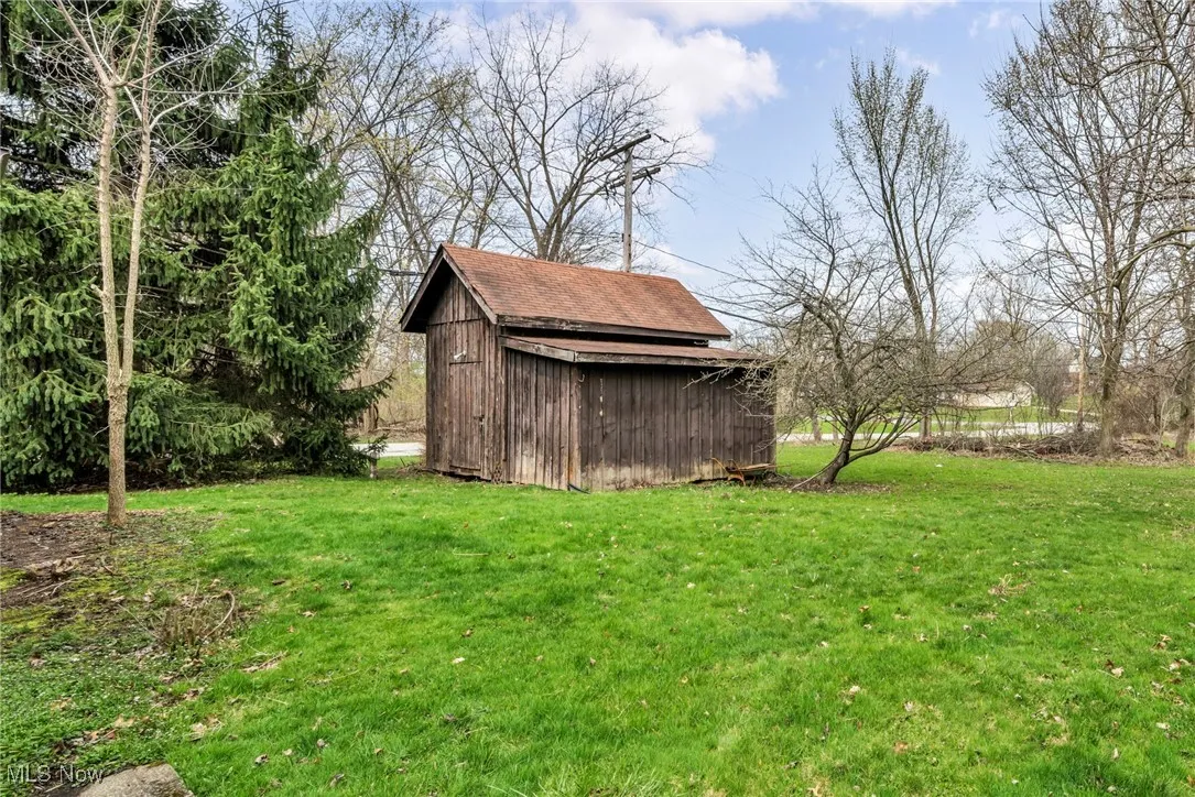 View of yard with an outbuilding and a storage shed