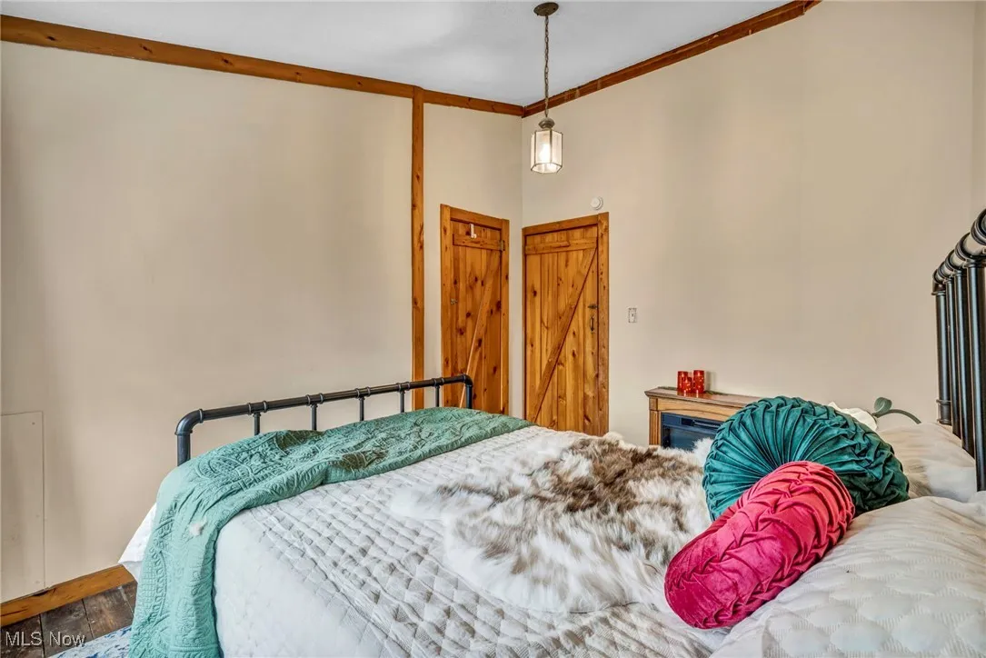 Bedroom featuring wood finished floors and ornamental molding