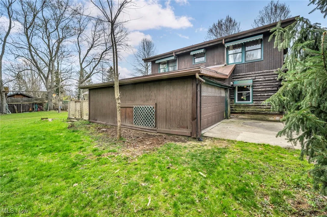 Back of property featuring a lawn and driveway