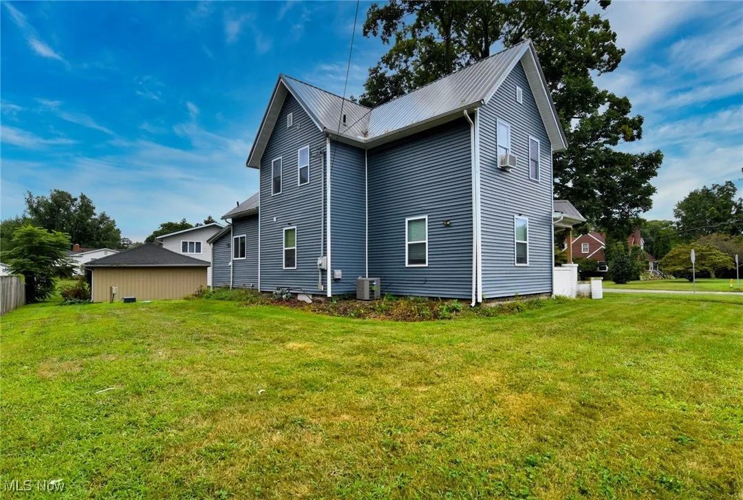 Rear view of property with a yard and a metal roof