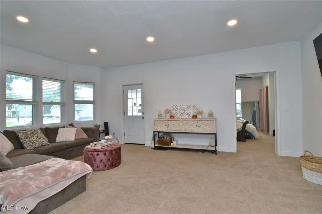 Living room with light carpet and recessed lighting