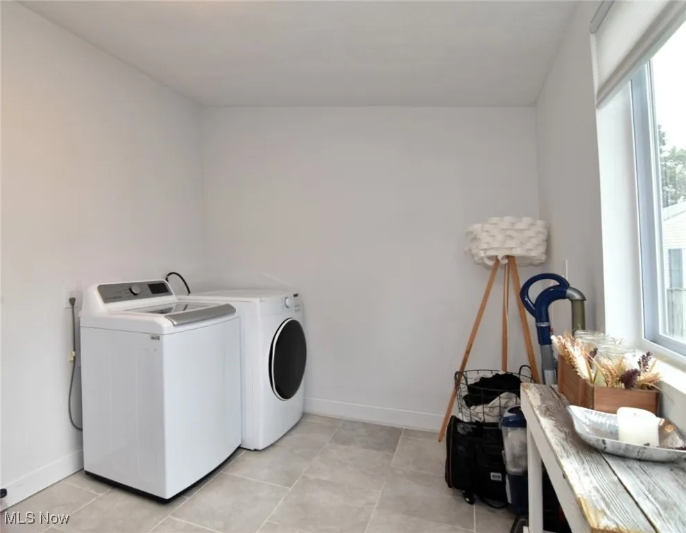 Laundry room with baseboards and washer and dryer