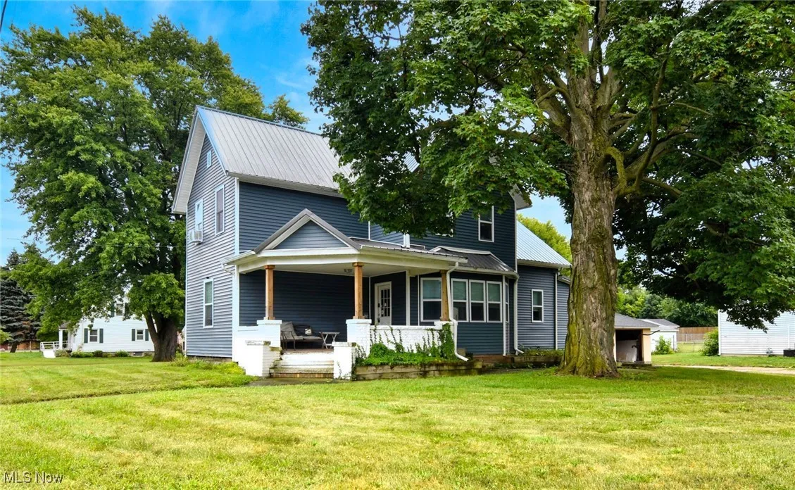 View of front of house featuring a front lawn and a metal roof