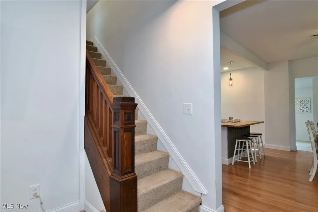 Stairway featuring baseboards and wood finished floors