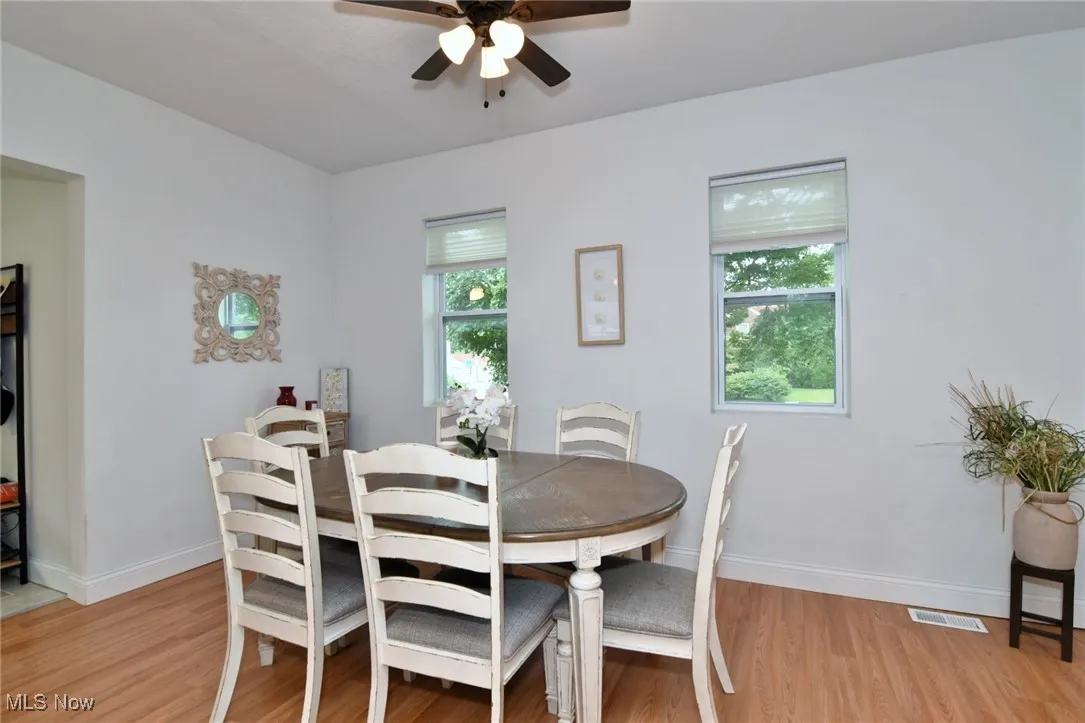 Dining space with light wood-style floors, plenty of natural light, and a ceiling fan