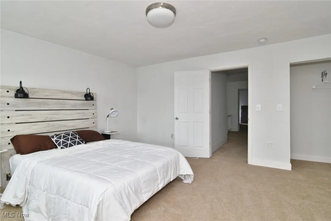 Bedroom featuring light carpet