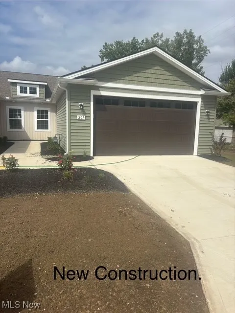 Single story home featuring concrete driveway, a garage, and board and batten siding