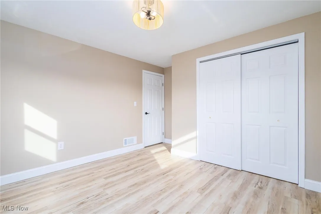 Unfurnished bedroom with light wood-style flooring and a closet