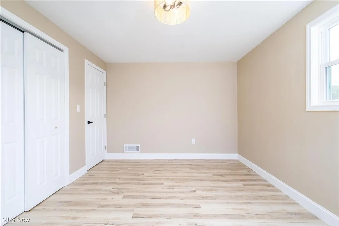 Unfurnished bedroom with light wood-style flooring and a closet