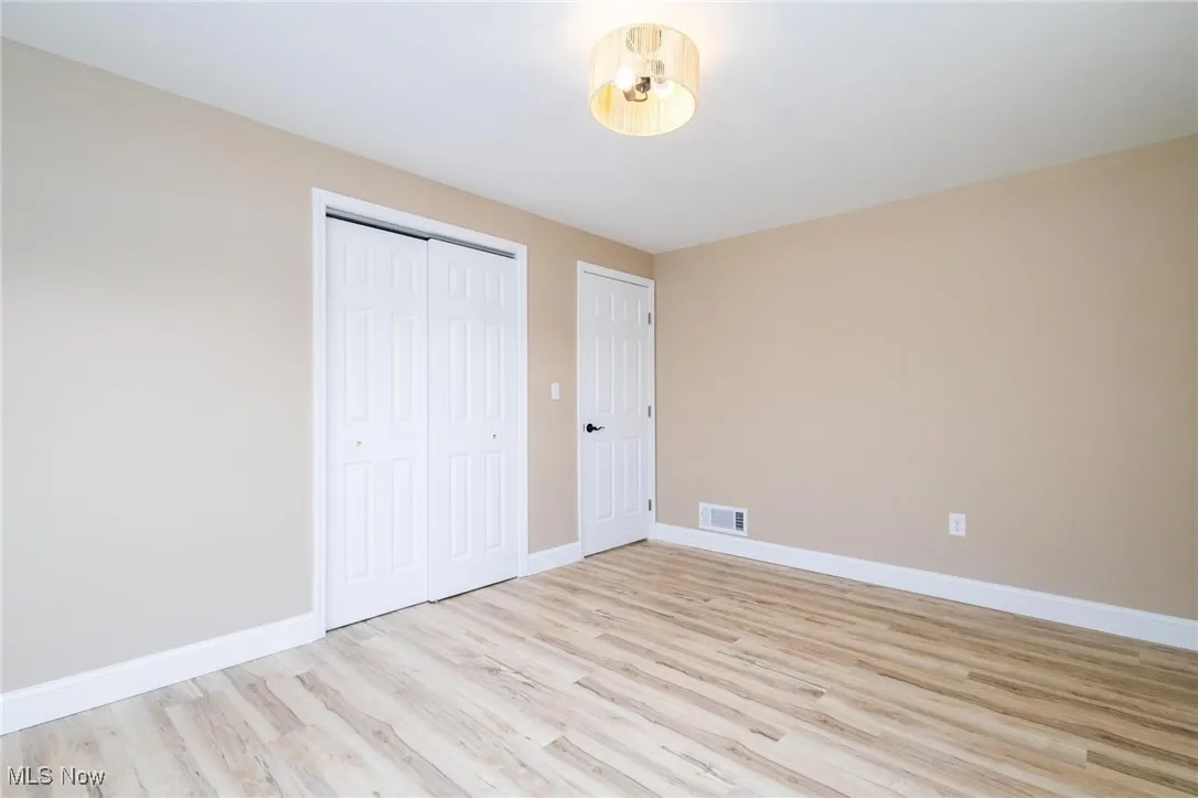 Unfurnished bedroom featuring light wood finished floors and a closet
