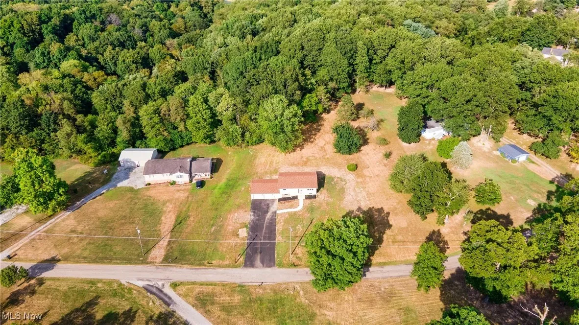 Aerial view of property's location with a heavily wooded area
