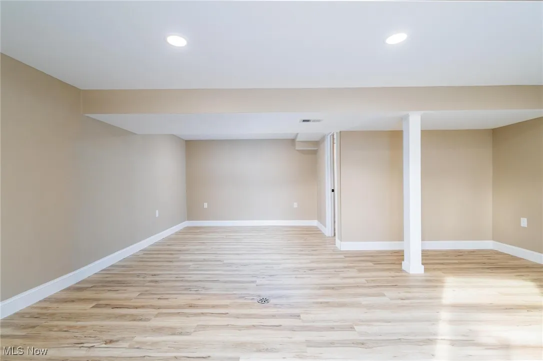Finished basement featuring light wood-style floors and recessed lighting