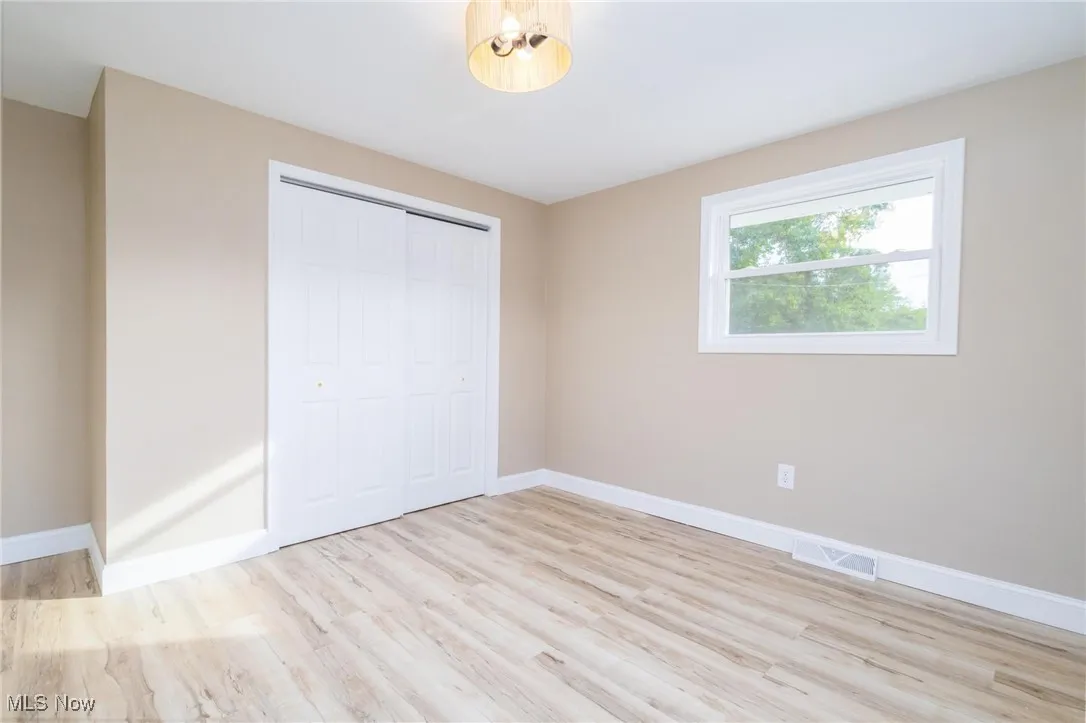 Unfurnished bedroom with light wood finished floors and a closet