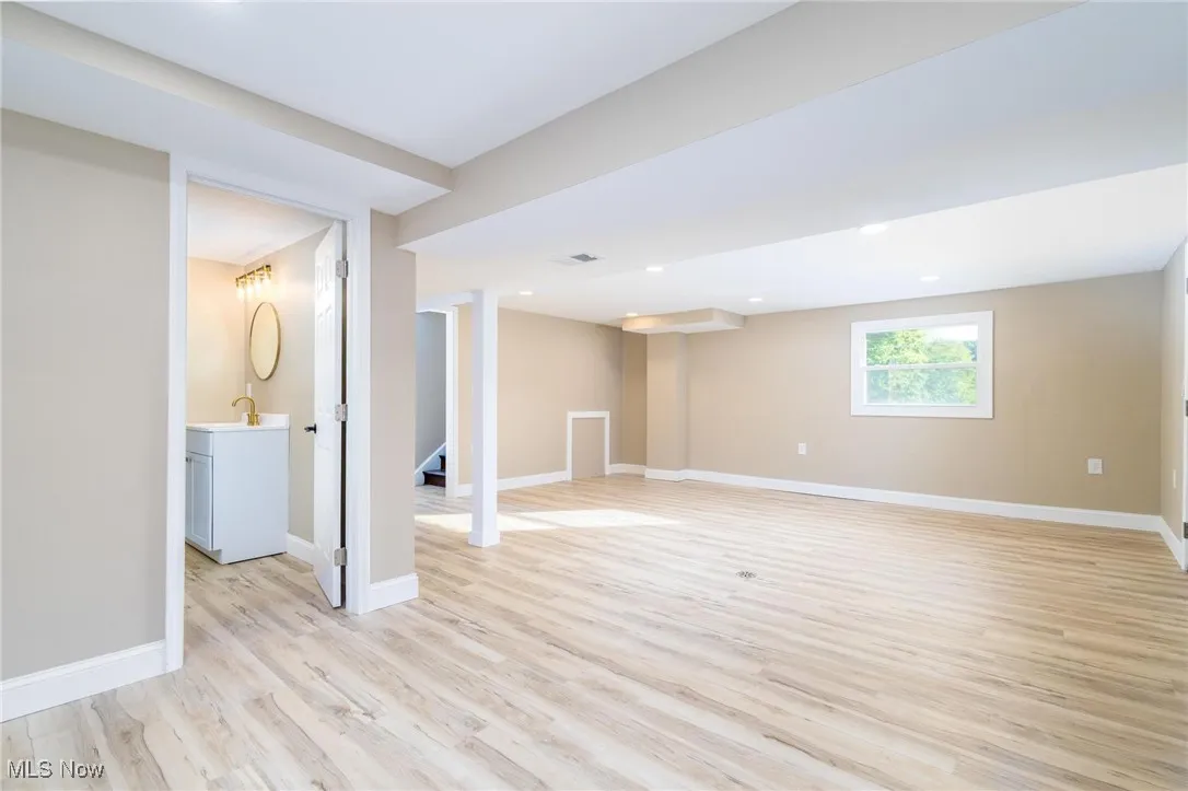 Below grade area with light wood finished floors and recessed lighting