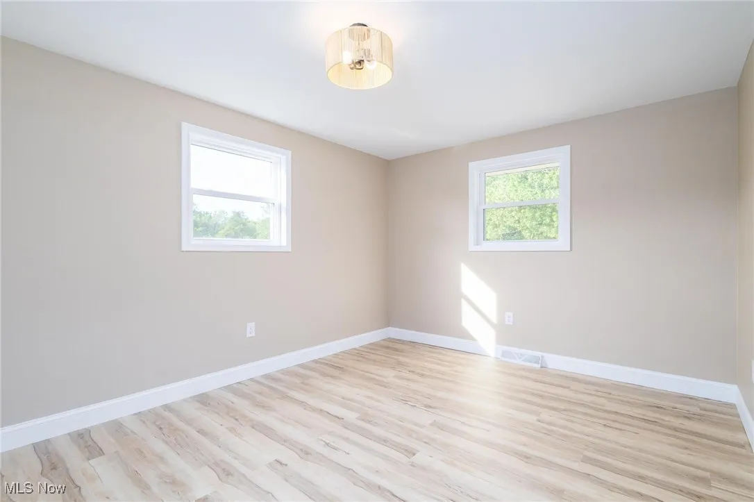 Unfurnished room featuring light wood-type flooring and baseboards