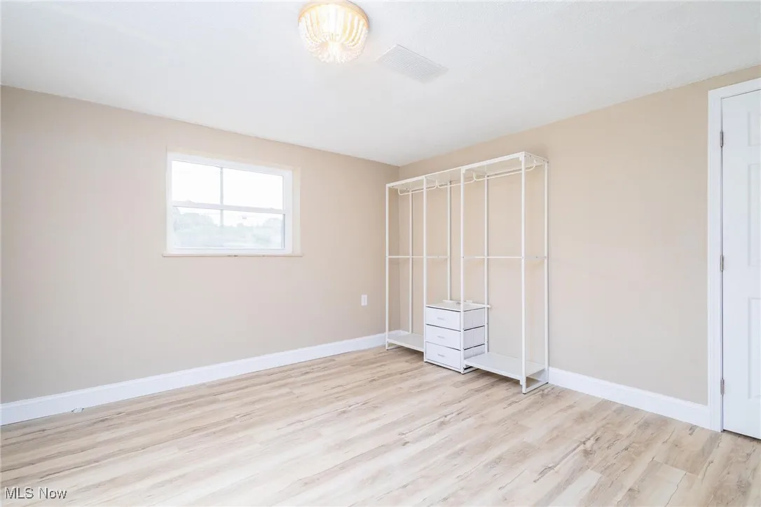 Unfurnished bedroom featuring light wood-style flooring and baseboards