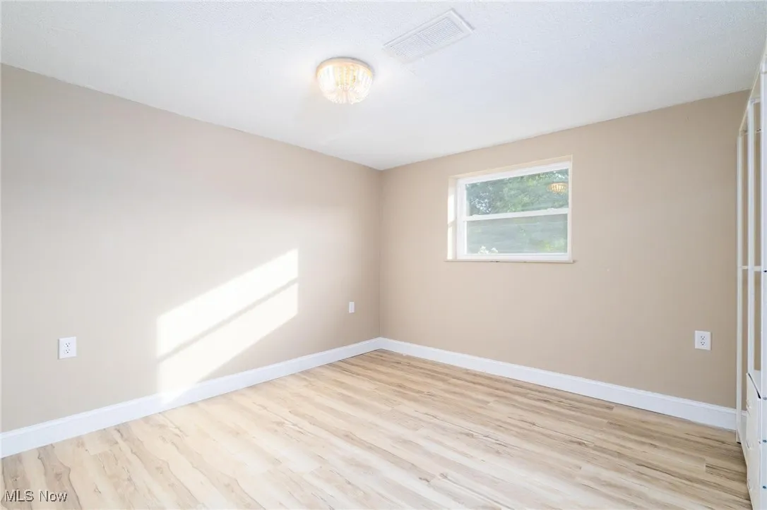 Unfurnished room featuring light wood-type flooring and baseboards