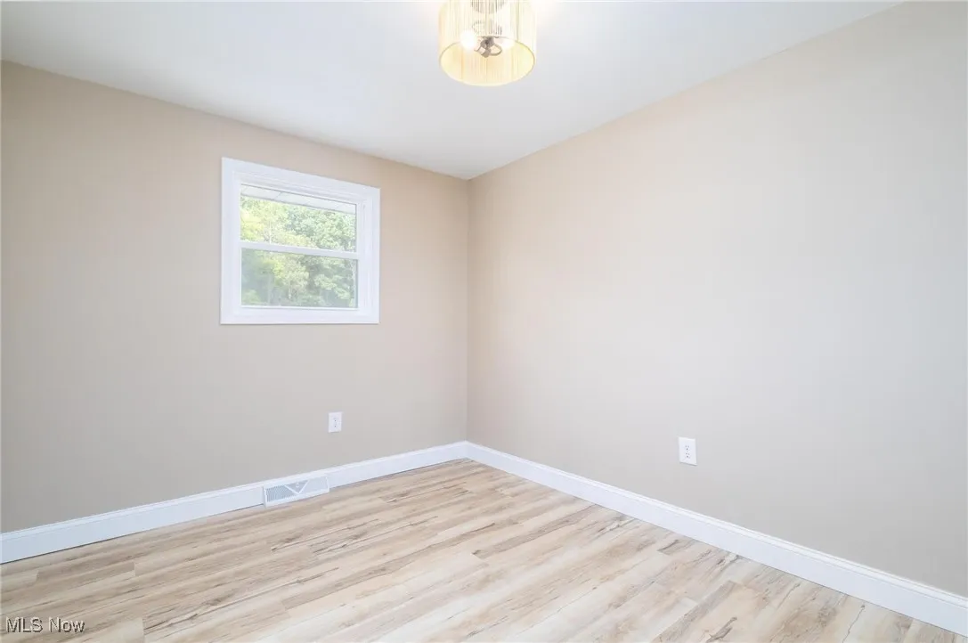 Empty room featuring light wood-type flooring and baseboards