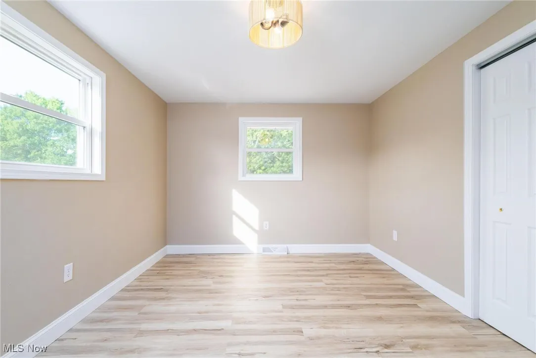 Unfurnished bedroom with light wood-style flooring and a closet