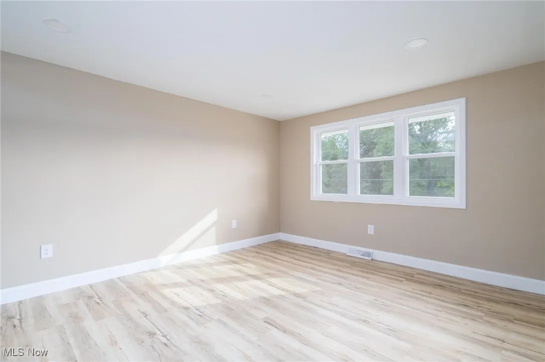 Empty room featuring light wood finished floors and recessed lighting